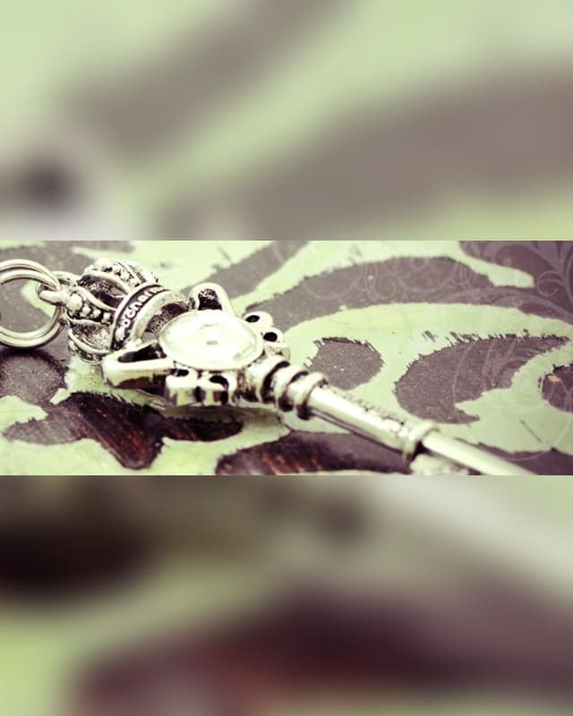 Silver key charm with crown