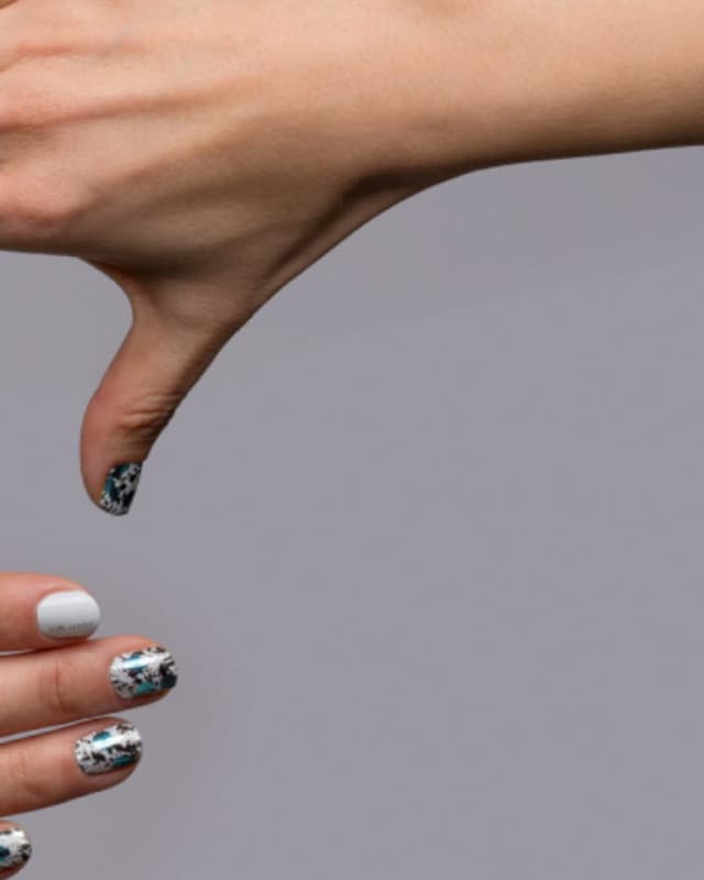 Metallic silver and teal nail wraps being worn