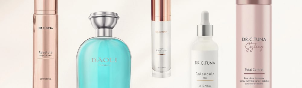Farmasi Dr. C. Tuna Absolute elixir, Baoli fragrance, Age Reversist serum, Calendula oil and Styling hairspray lined up on a cream background