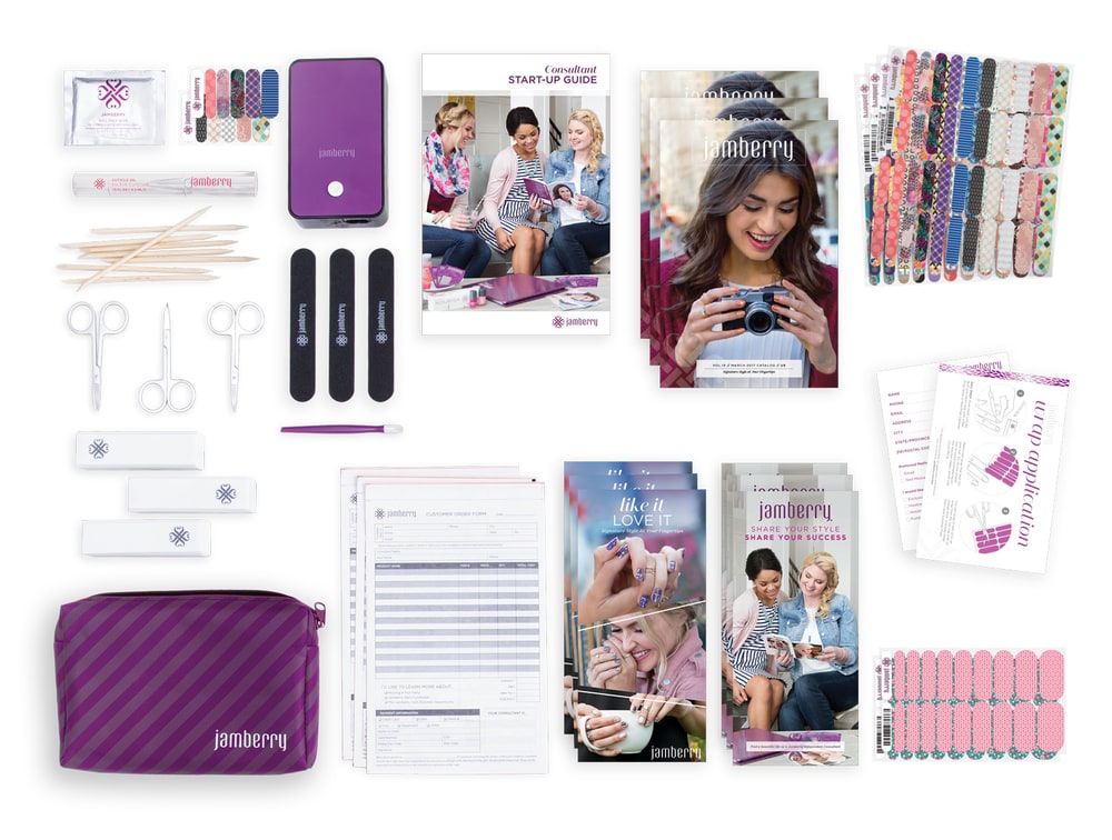 The contents of a Jamberry Consultant starter kit laid out: catalogs, start-up guide, order forms, mini heater, scissors, files, orange sticks and sheets of nail wraps