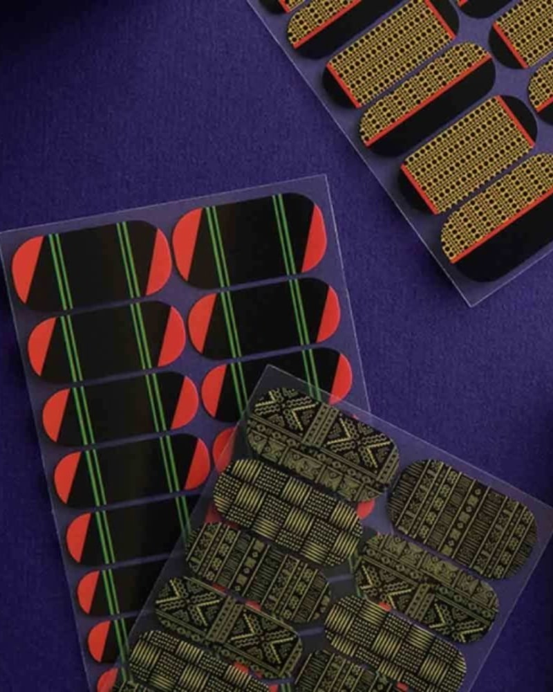 Sheets of patterned nail wraps in black, gold, red and green