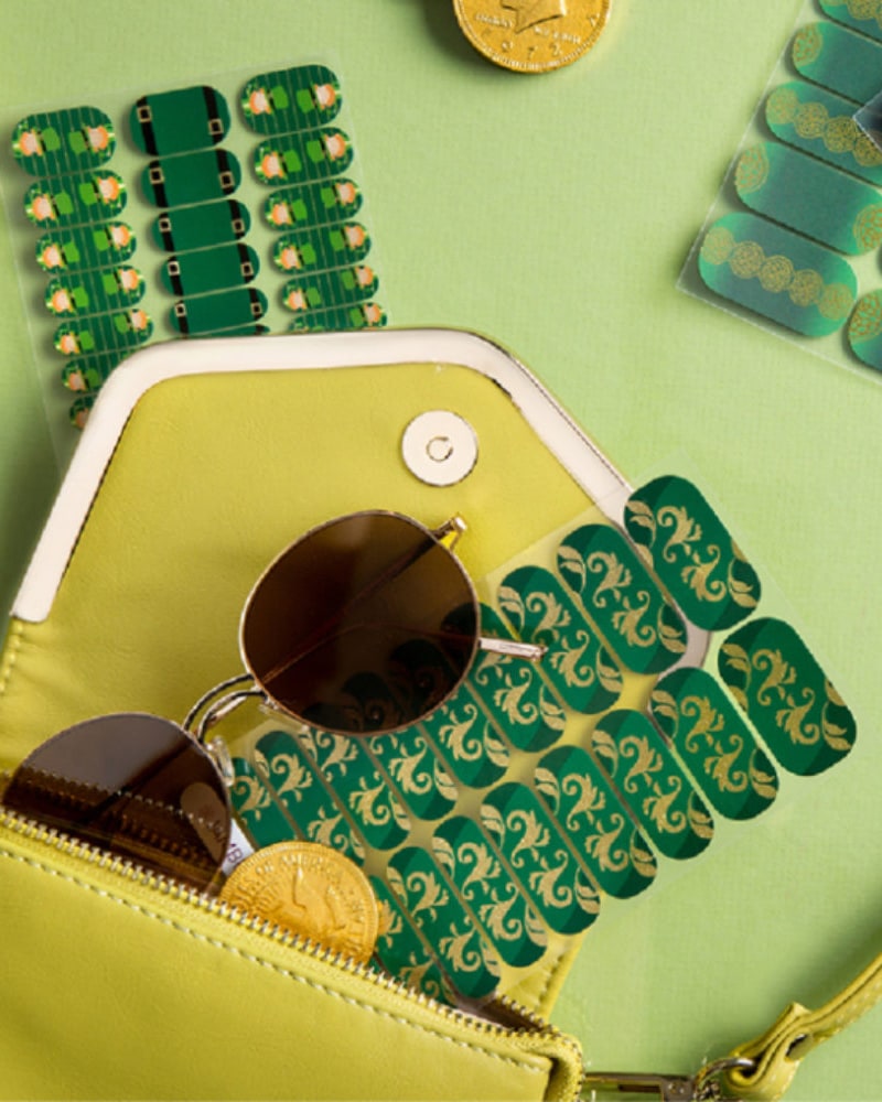 Green and gold nail wrap sheets spilling from a handbag