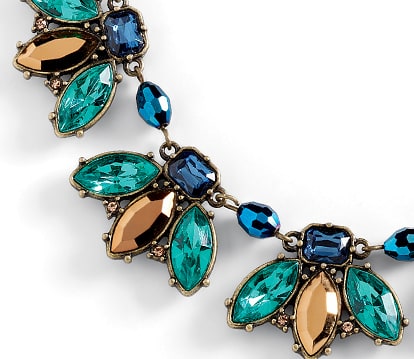 Close-up of a Lia Sophia statement necklace with teal and copper marquise crystals and blue beads on an antiqued gold-tone setting