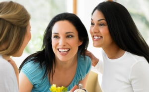Three smiling women chatting together at a relaxed get-together
