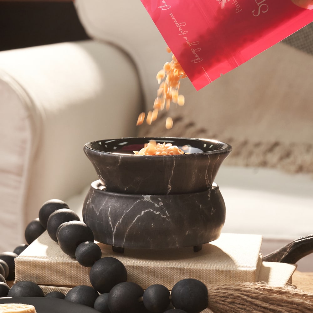 Sprinkles wax melts being poured from a bag into a Pink Zebra Black Marble Simmer Pot
