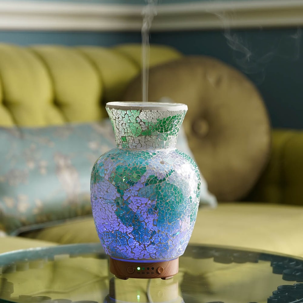 Pink Zebra Teal Tranquil Vase ultrasonic aroma diffuser misting on a glass table