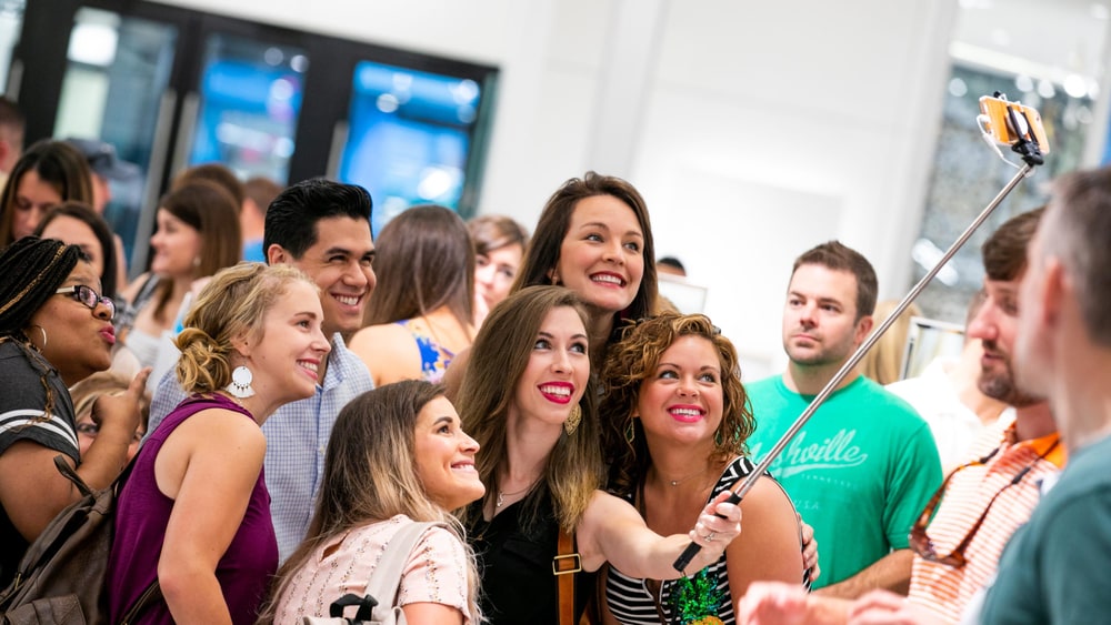 Smiling Plexus Brand Ambassadors taking a group selfie at a company event