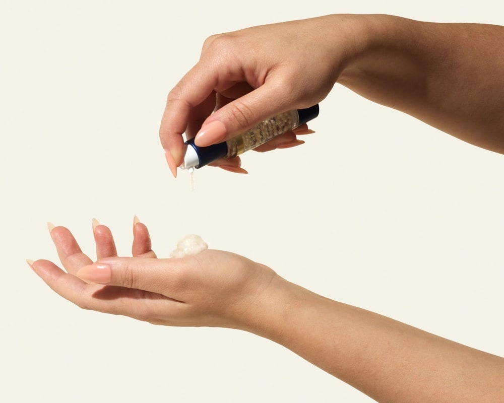 Hand squeezing a SeneGence serum onto an open palm