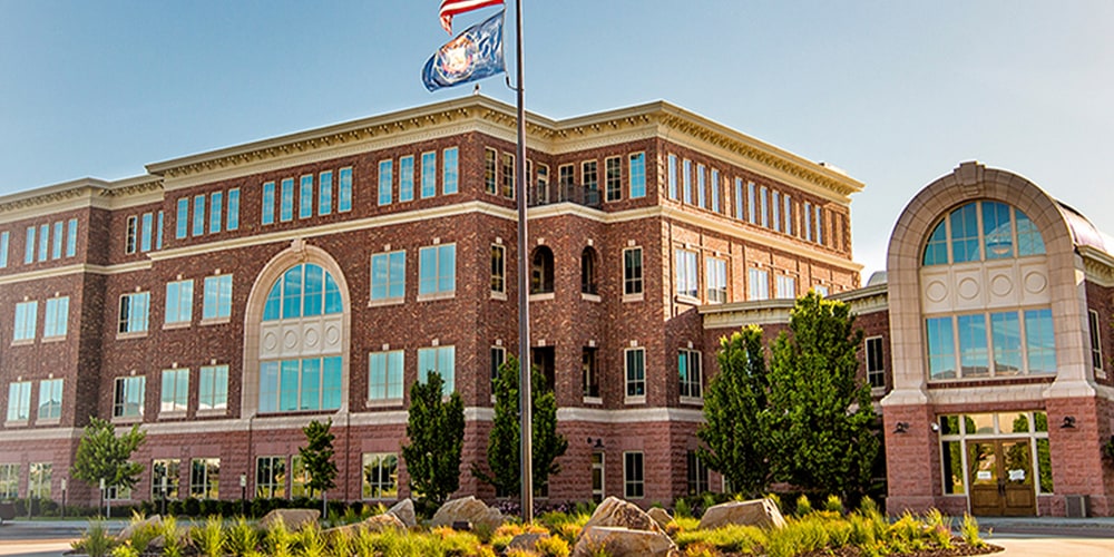Red brick Stampin' Up! office building with arched windows and a flagpole flying the US and Utah flags