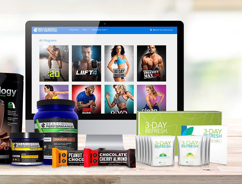 Beachbody On Demand on a desktop screen behind Shakeology, Beachbody Performance tubs, Beachbars and a 3-Day Refresh kit
