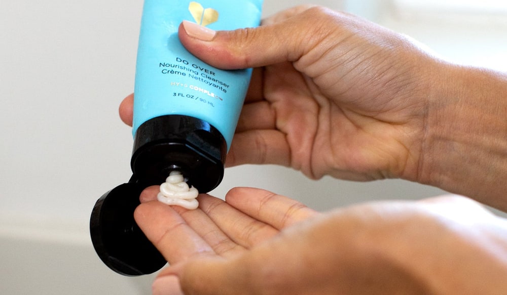 Hands squeezing Do Over nourishing cleanser from a turquoise tube into an open palm