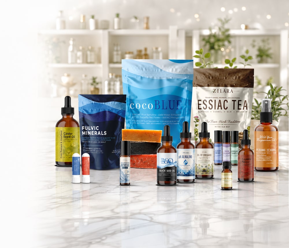 Zilara products on a marble counter: Castor Seed Oil, Fulvic Minerals, cocoBLUE, Essiac Tea, Black Seed Oil, pH Alkaline, Oil of Oregano, roll-ons, soaps and GOGOStix inhalers